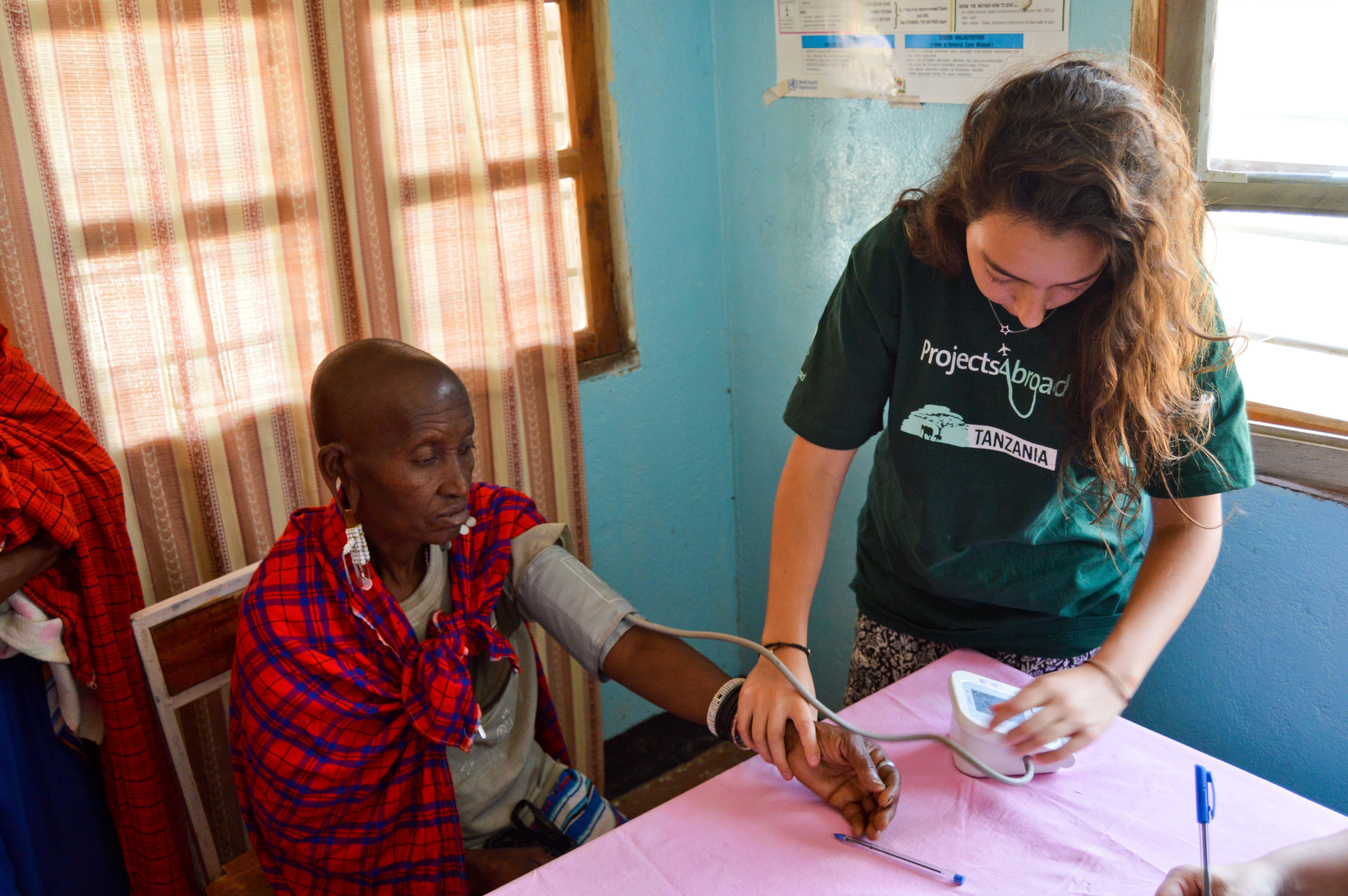 En Tanzania, pasante de medicina revisa a pacientes de una clínica rural. Pasante de medicina en Tanzania toma los signos vitales de un paciente.